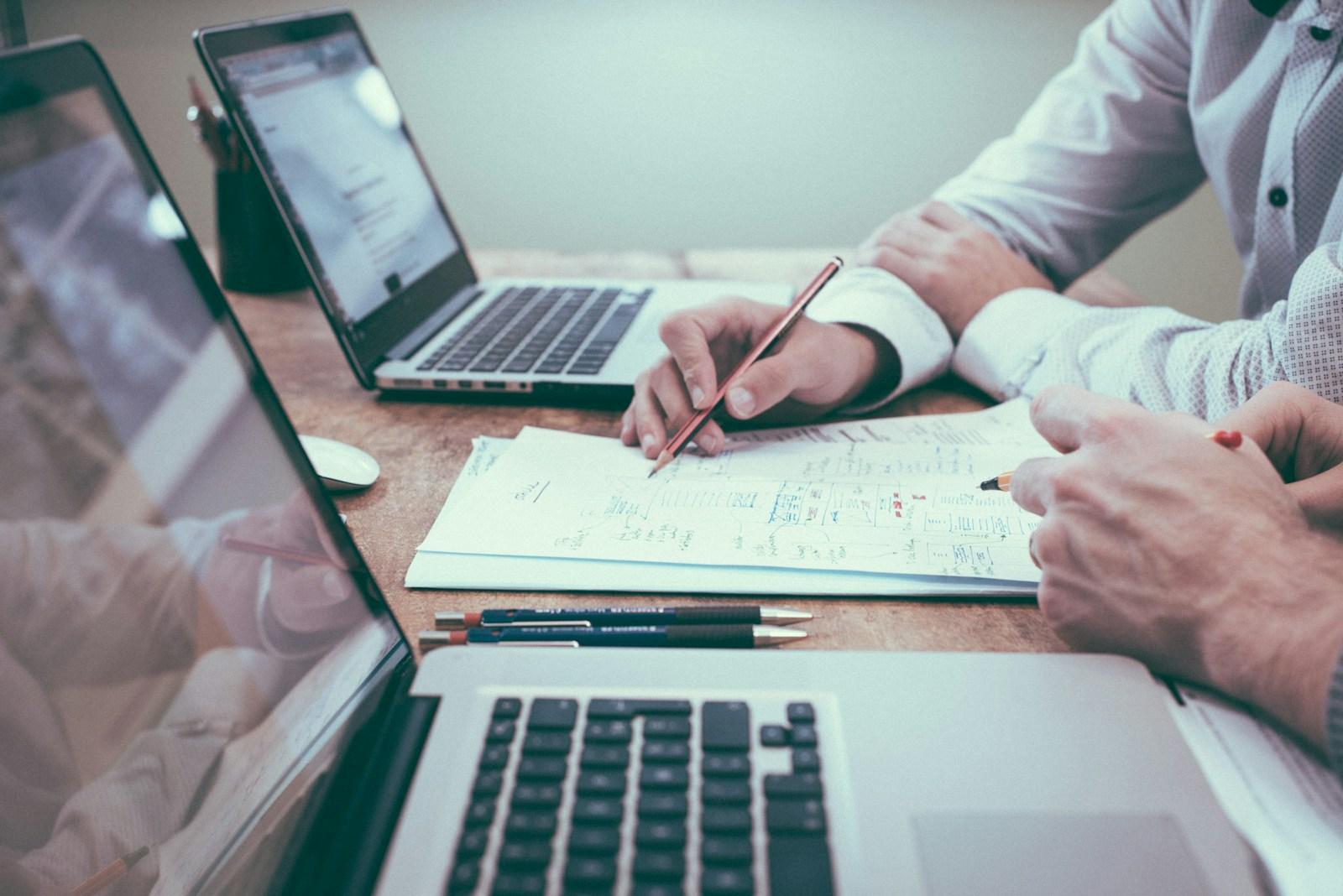 Business documents and notes reviewed at a wooden conference table