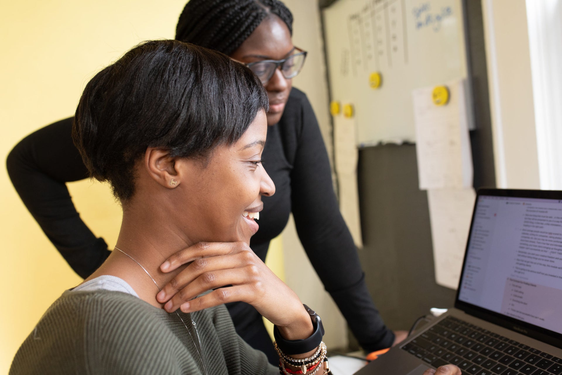 Two colleagues reviewing work together in a collaborative office setting