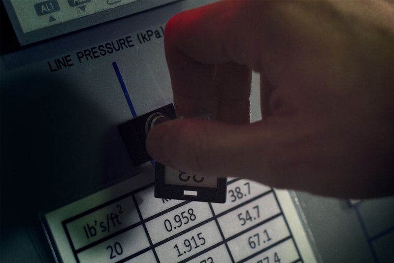 Technician monitoring line pressure on utility equipment